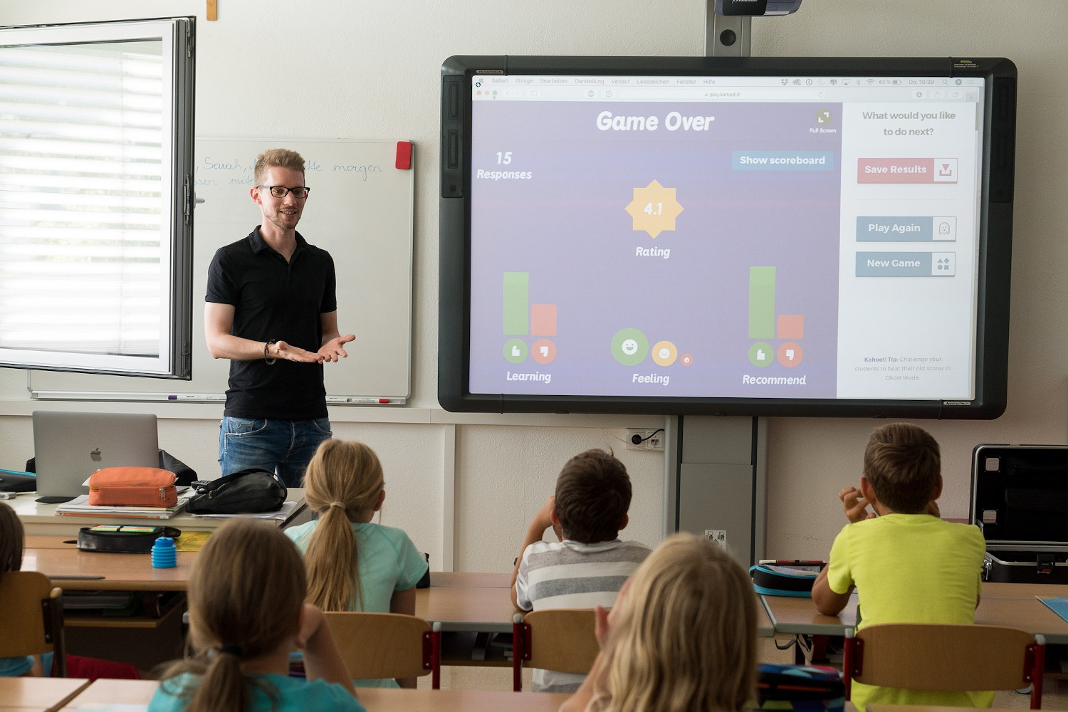 Ein Lehrer zeigt Schülern in einer Klasse Inhalte auf einem Smartboard